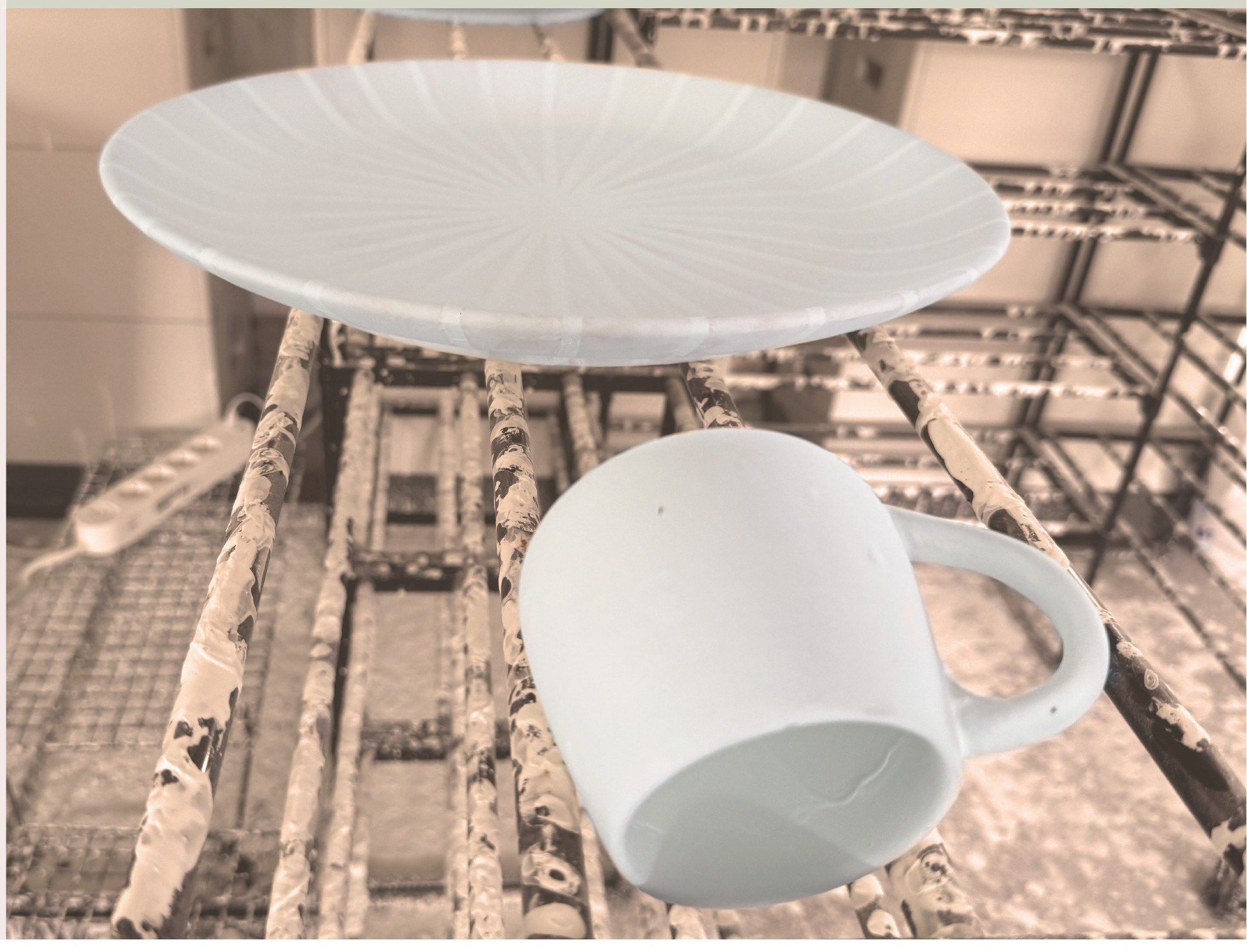 Gebrannte Keramikteller und Tasse im Brennofen